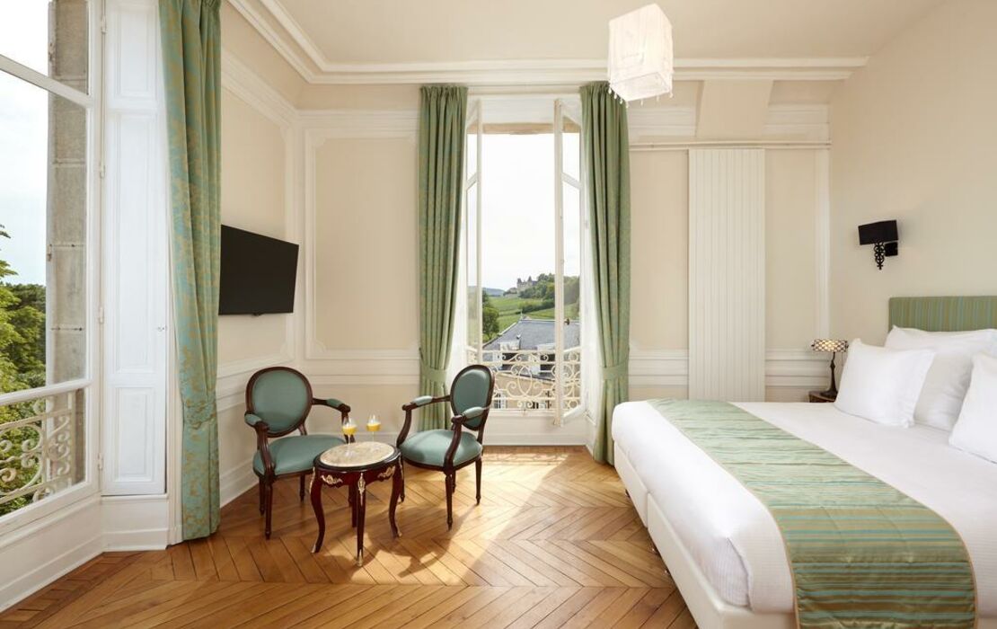 Elegant French hotel room with classic molding, green curtains and countryside view